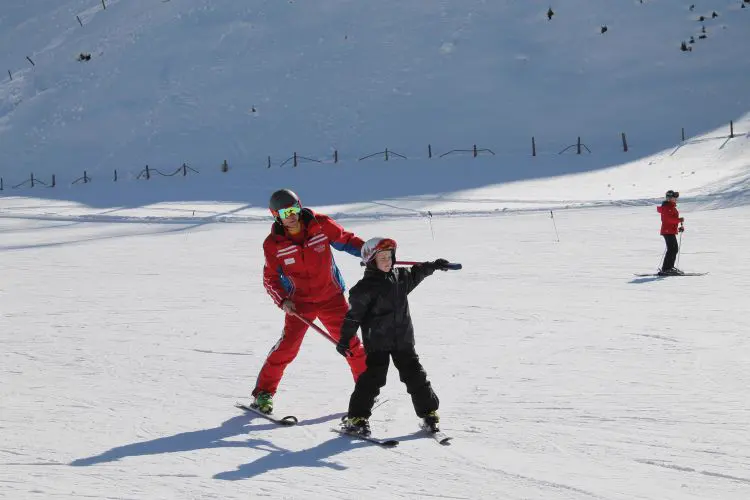 Skilehrer mit einem Kind auf der Piste