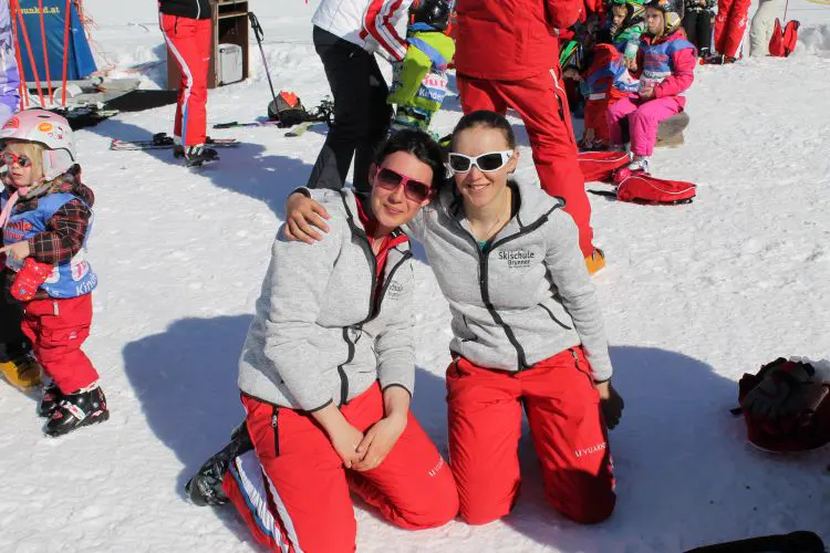 Skilehrerinnen mit Kind im Schnee