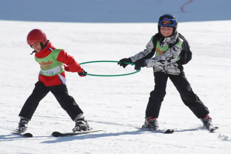 Skilehrer übt mit einem Kind mit dem Reifen