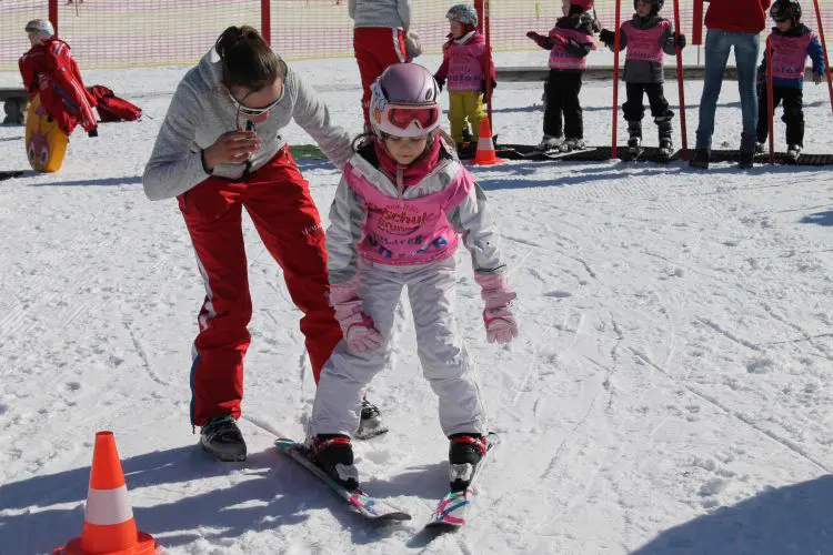 Skilehrerin hilft einem Kind