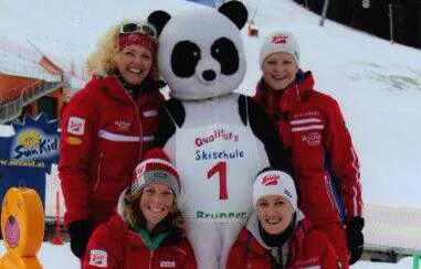 Skilehrerinnen mit dem Panda-Maskottchen